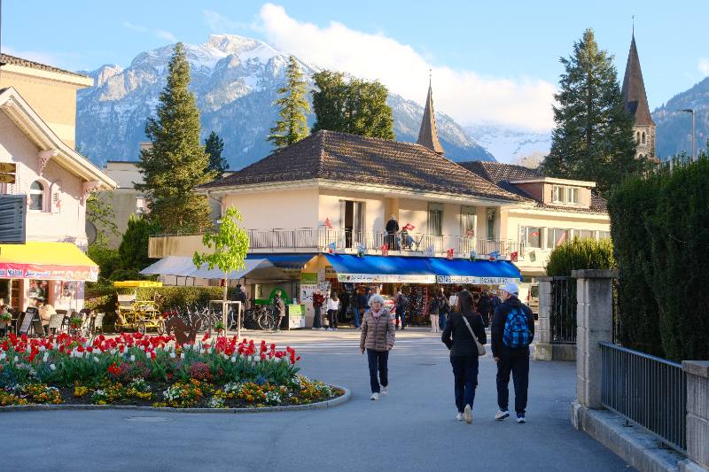 Example travel photograph of a mountain town, church tower, and public garden