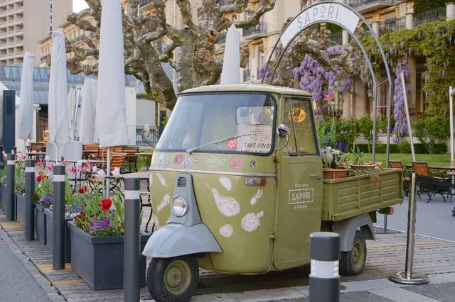 Three-wheel delivery vehicle parked outside a restaurant
