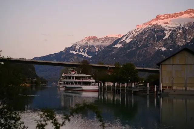 Passenger boat on a mountain lake beneath an evening sky